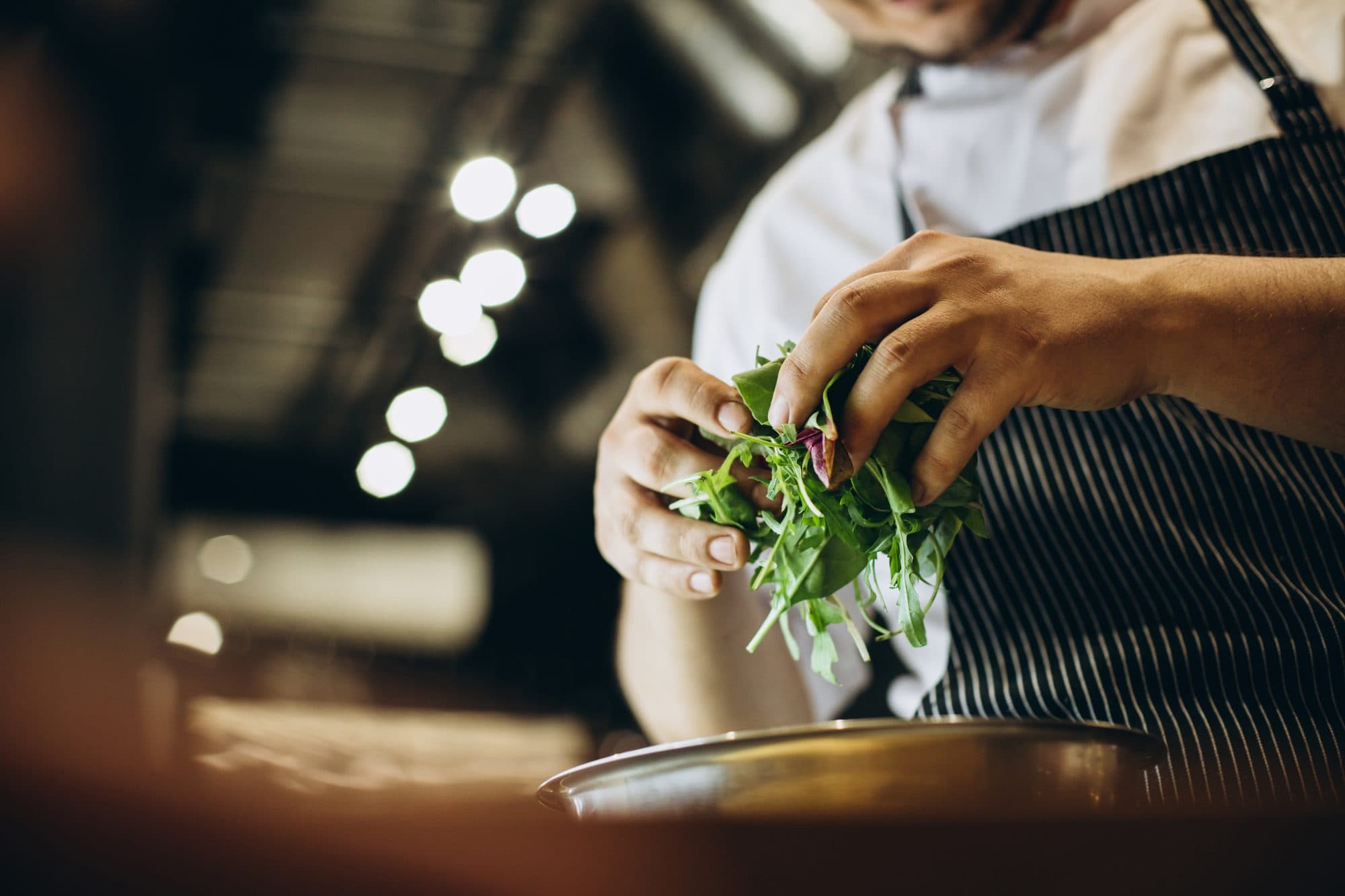 Koch bereitet frischen Salat in der Restaurantküche zu